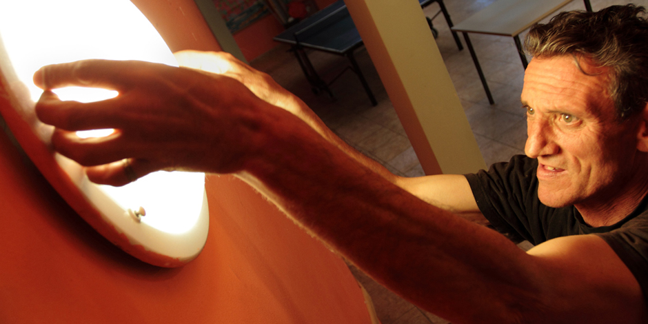 A man working on a light fitting in the Arrels workshop