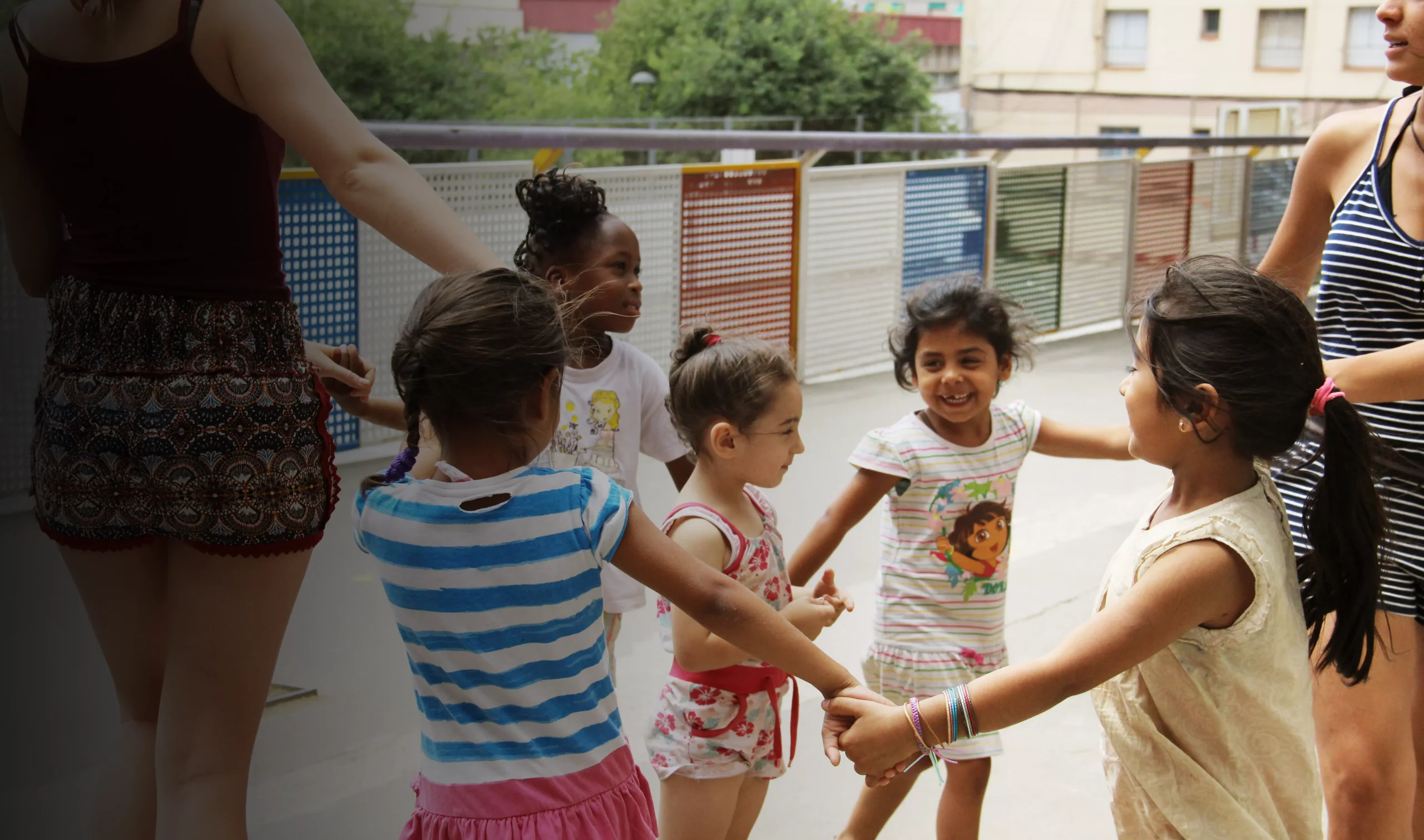 Children holding hands in a circle during a group activity